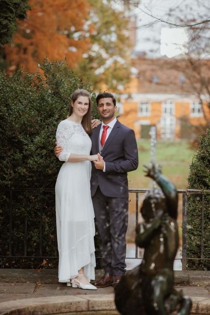 Braut und Bräutigam, frisch verheiratetes Paar, stehen Hand in Hand und posieren für ein Foto.