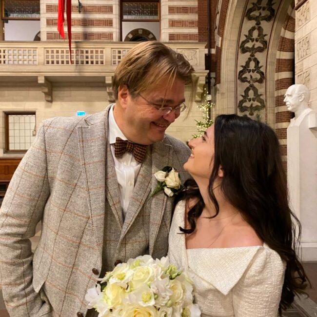 Frisch verheiratetes Paar blickt sich im Rathaus von Kopenhagen tief in die Augen.