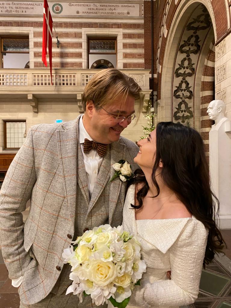 Frisch verheiratetes Paar blickt sich im Rathaus von Kopenhagen tief in die Augen.