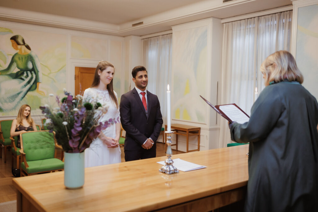 Heiraten in Dänemark: Hochzeitspaar bei der Trauung im Standesamt mit einer Standesbeamtin.