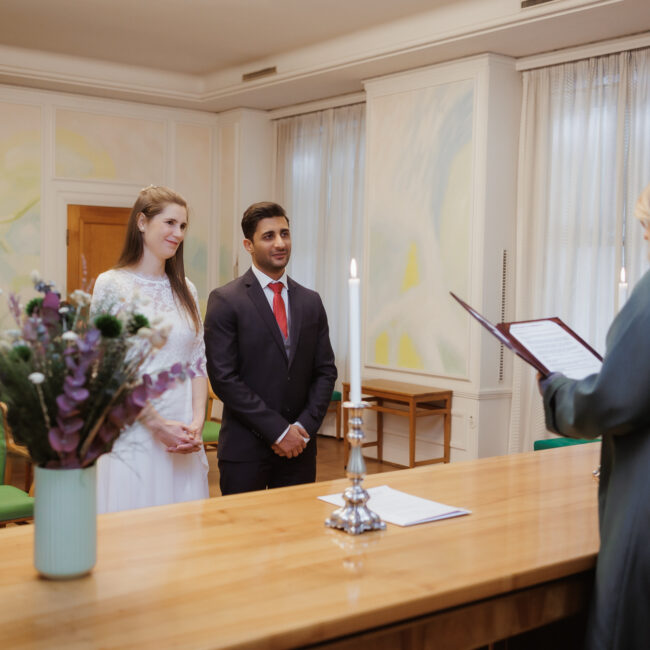 Heiraten in Dänemark: Hochzeitspaar bei der Trauung im Standesamt mit einer Standesbeamtin.