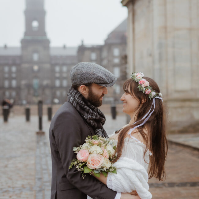 Heiraten in Dänemark: Brautpaar vor dem Christiansborg Schloss in Kopenhagen an einem romantischen Wintertag.