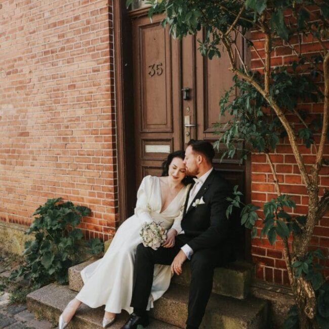 Paar nach dem Heiraten in Dänemark auf den Stufen des Standesamts.
