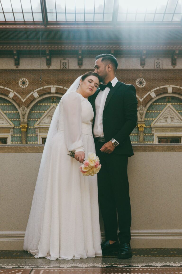 Heiraten in Denemarken: Ein Brautpaar in elegantere Kleidung steht liebevoll zusammen in einem historischen Gebäude nach der Trauung.