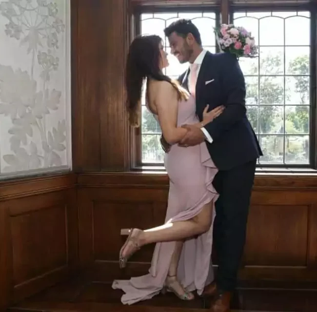 Heiraten in Dänemark: Ein glückliches Paar feiert seine Hochzeit in Dänemark, lächelnd vor einem historischen Fenster, das die Vorteile einer Hochzeit in Dänemark zeigt.