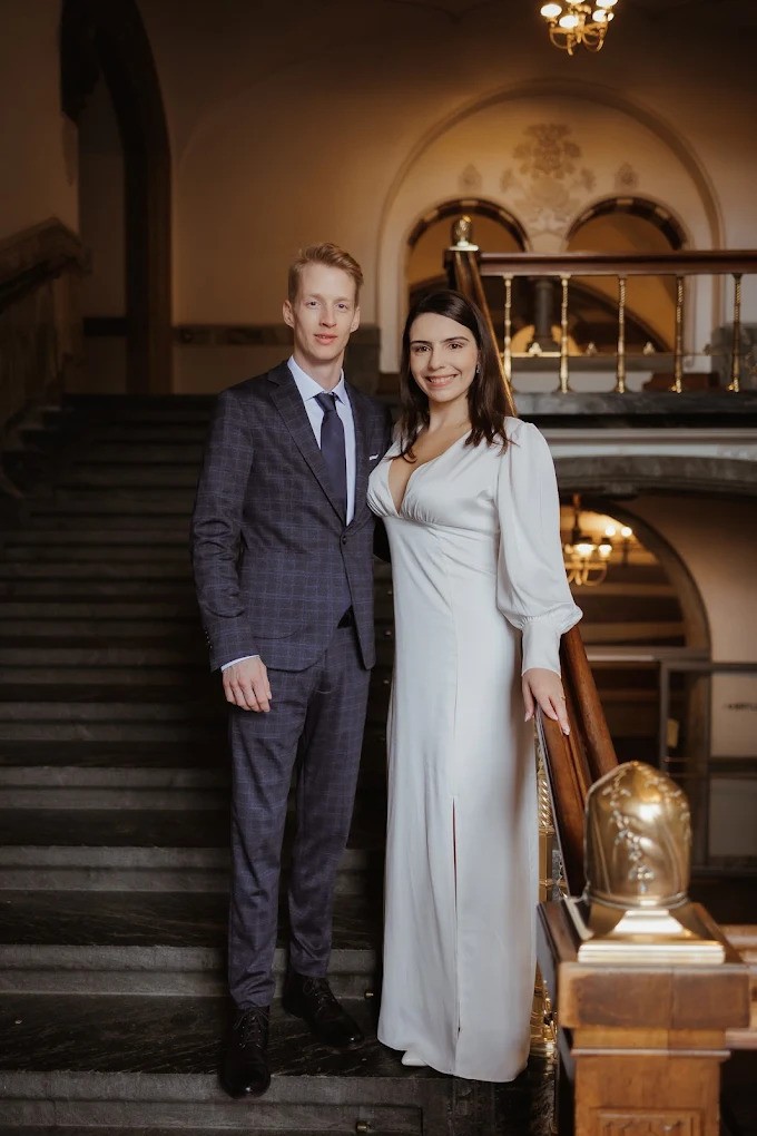 Frisch verheiratetes Paar posiert auf einer Treppe für ein Hochzeitsfoto
